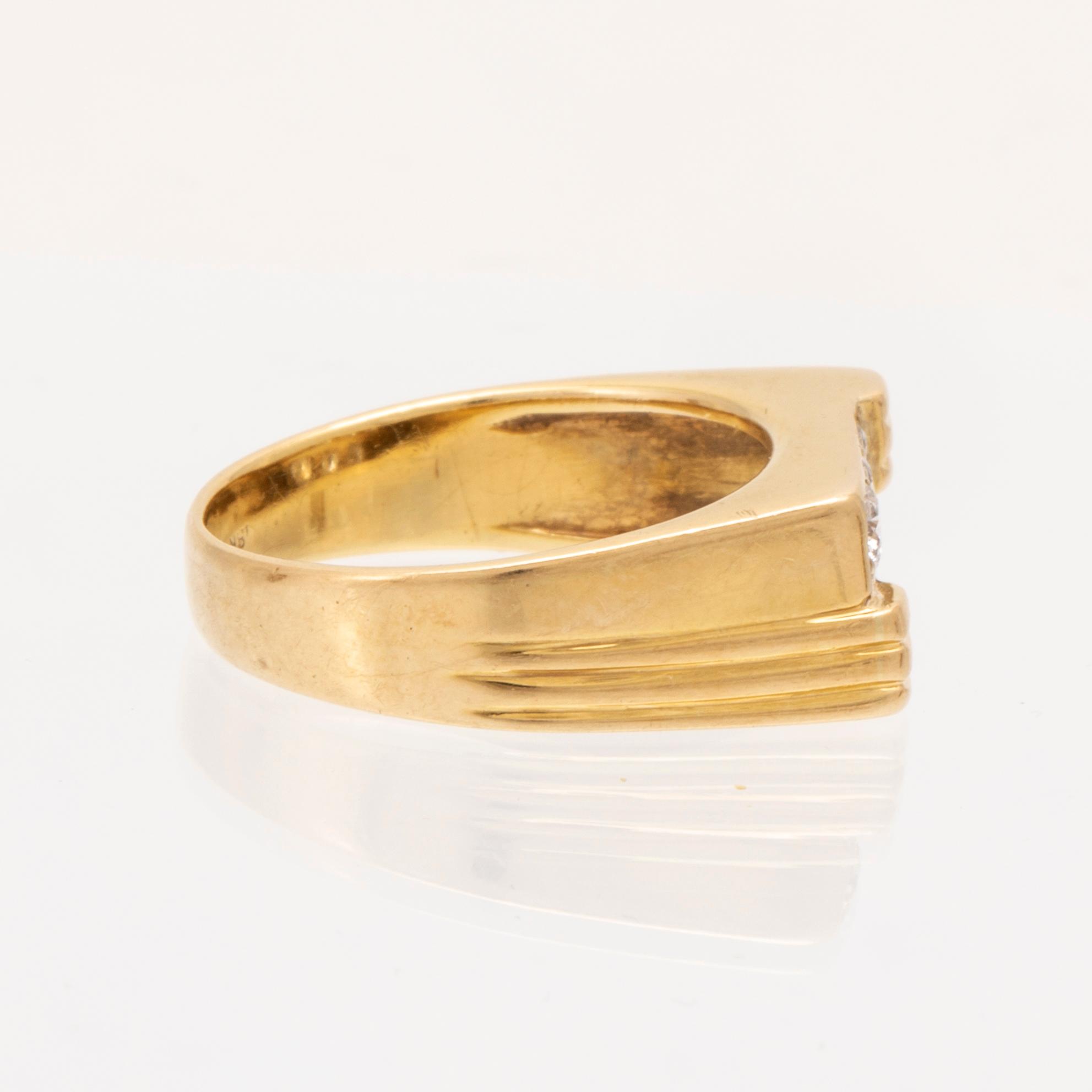 An 18K gold ring set with round brilliant cut diamonds.