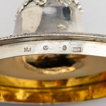 A Swedish Empire silver sugar bowl with lid and a suger sprinkle spoon, marks of Adolf Zethelius, Stockholm 1819.