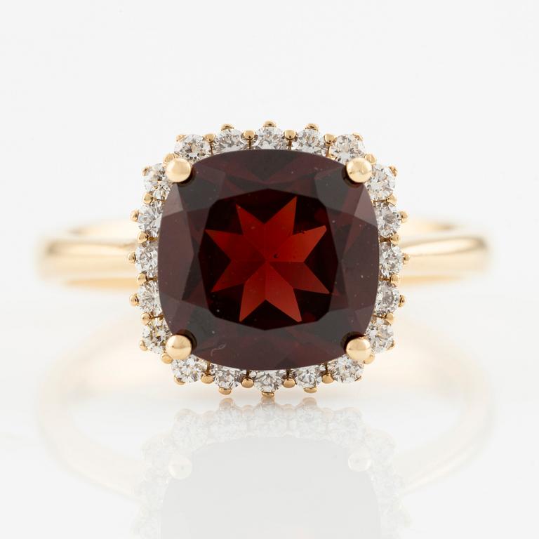 Ring in 18K gold with a faceted garnet and round brilliant-cut diamonds.