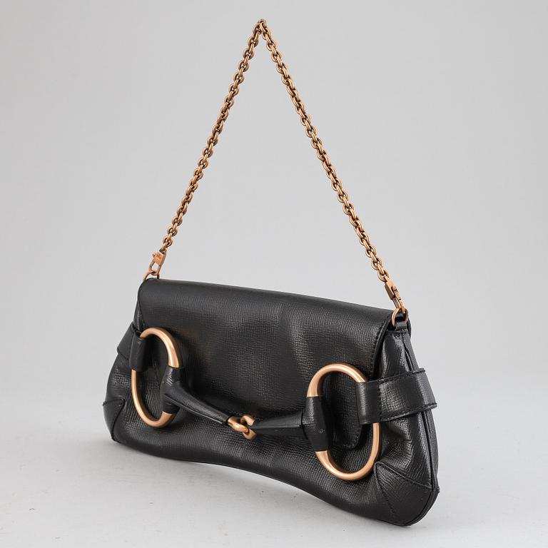 GUCCI, a black leather handbag.