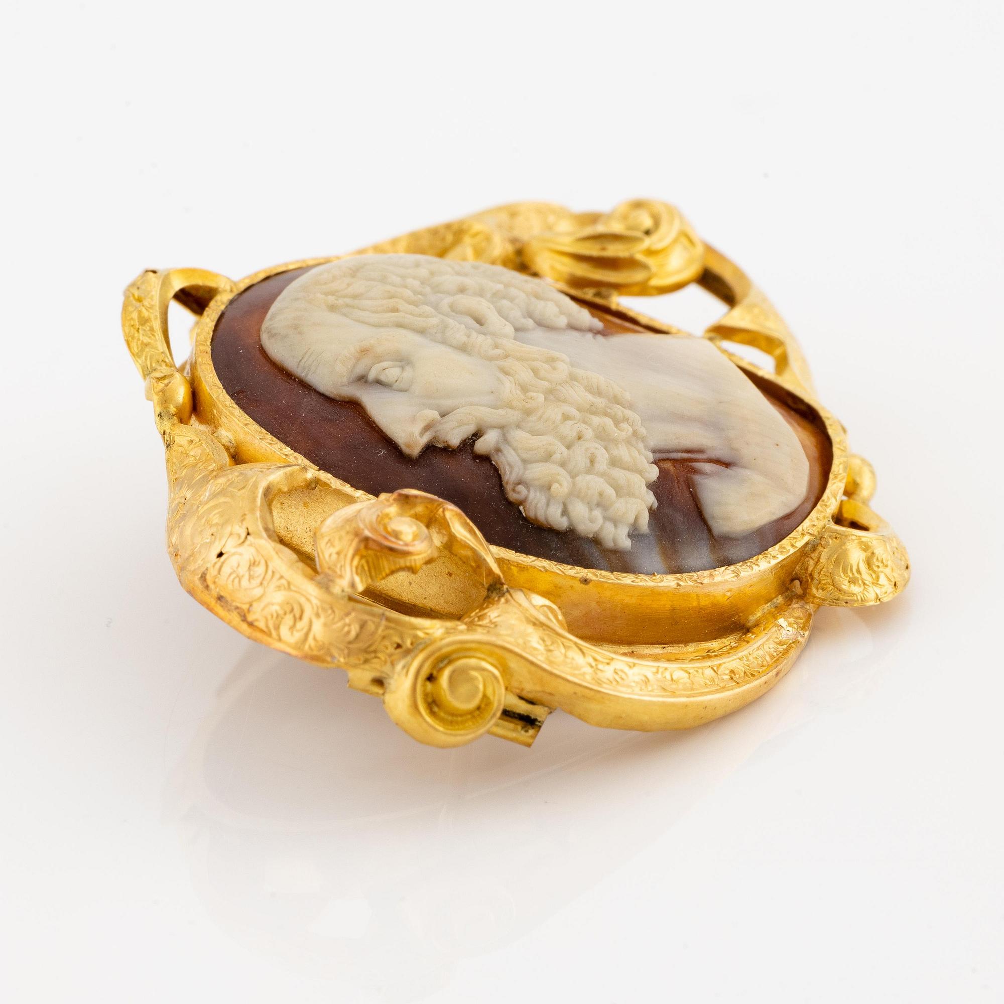 An 18K gold brooch with a hardstone cameo.