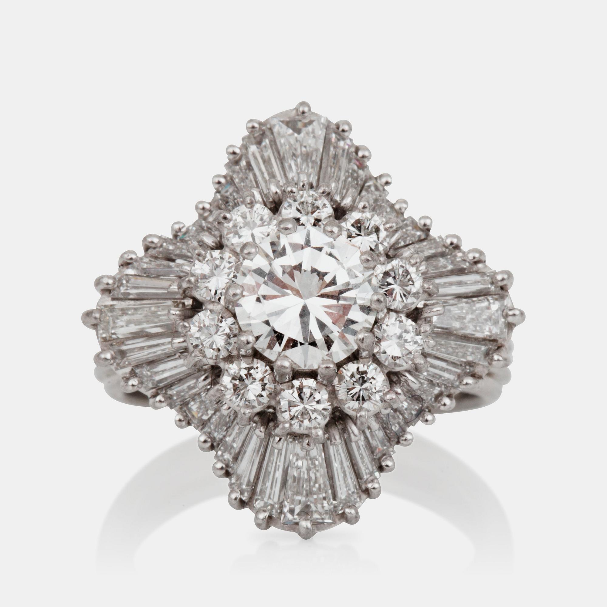 A brilliant- and trapezoid-cut diamond ring. Center diamond circa 1.10 cts and surrounding diamonds circa 1.00 ct.