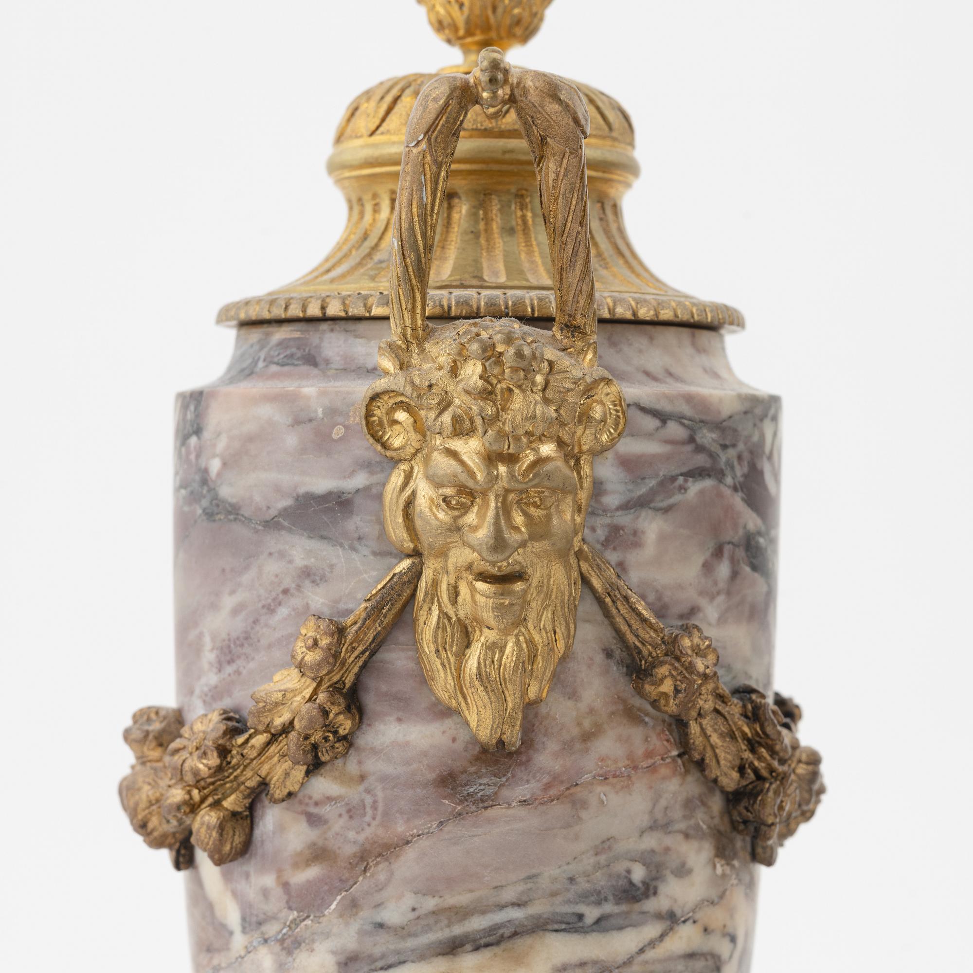 A pair of Louis XVI style urns with covers.