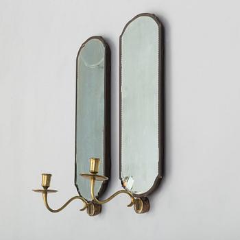 A pair of mirrors with candle sconces, partly 18th century.