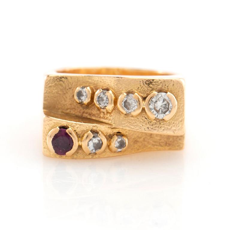 Ring in 18K gold set with round brilliant-cut diamonds and a round faceted gemstone.