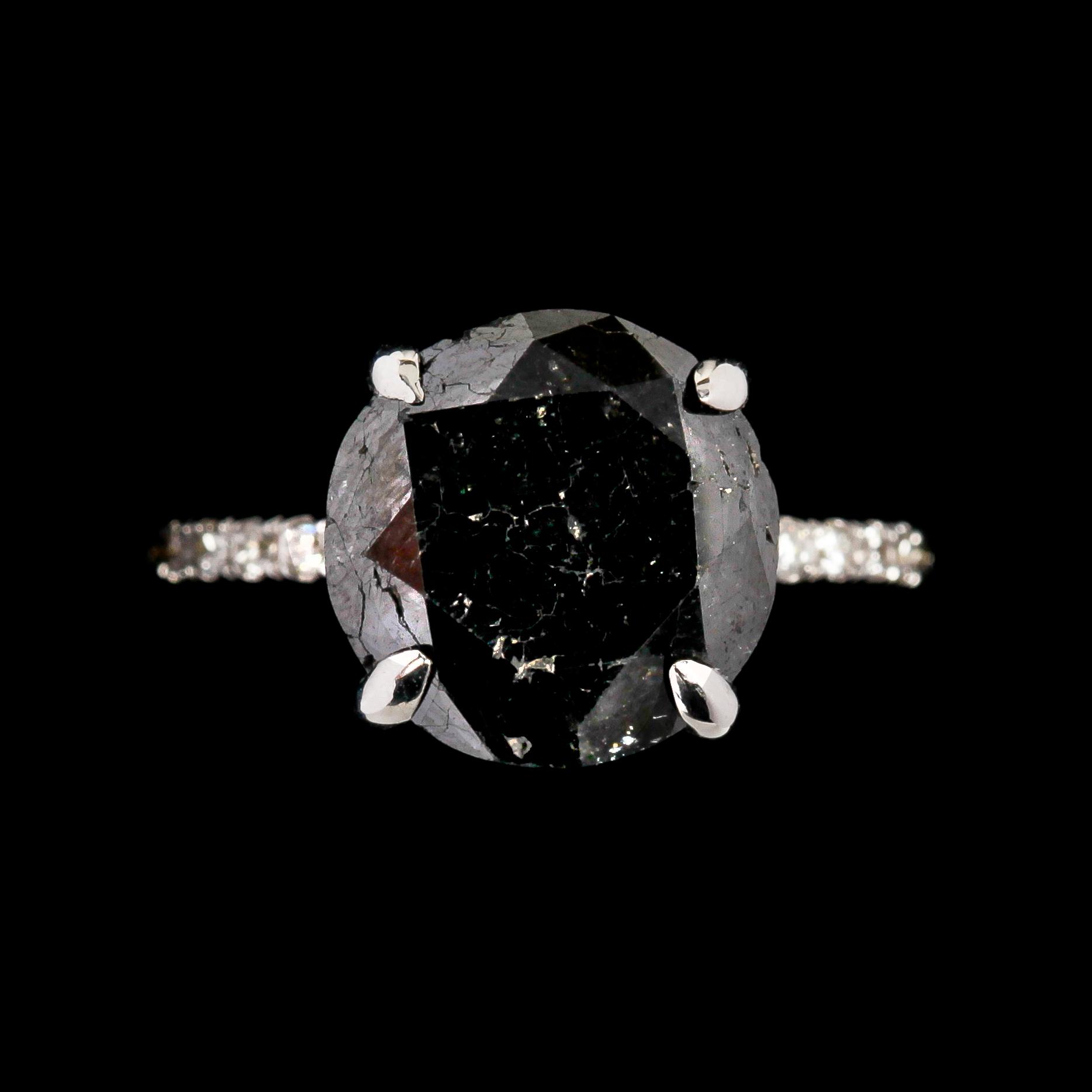 RING, svart briljantslipad diamant, 6.40 ct samt små vita briljantslipade diamanter, tot. 0.40 ct.