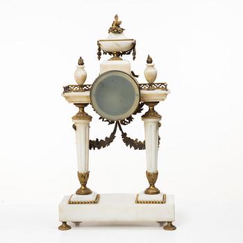A Louis XVI-style mantle clock and a pair of candelabras. Early 20th century.