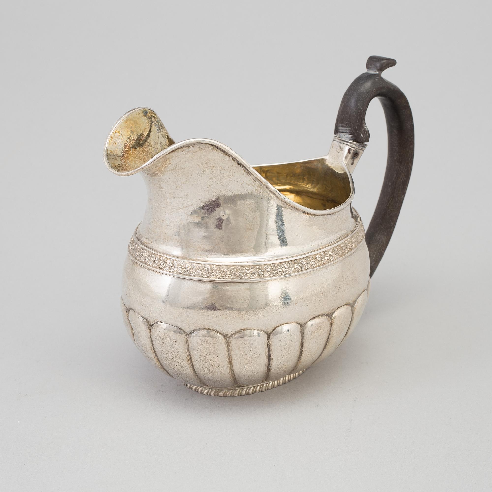 A Russian Empire parcel-gilt cream jug, maker's mark Elias Modig (1795-1834), St Petersburg, 1824.