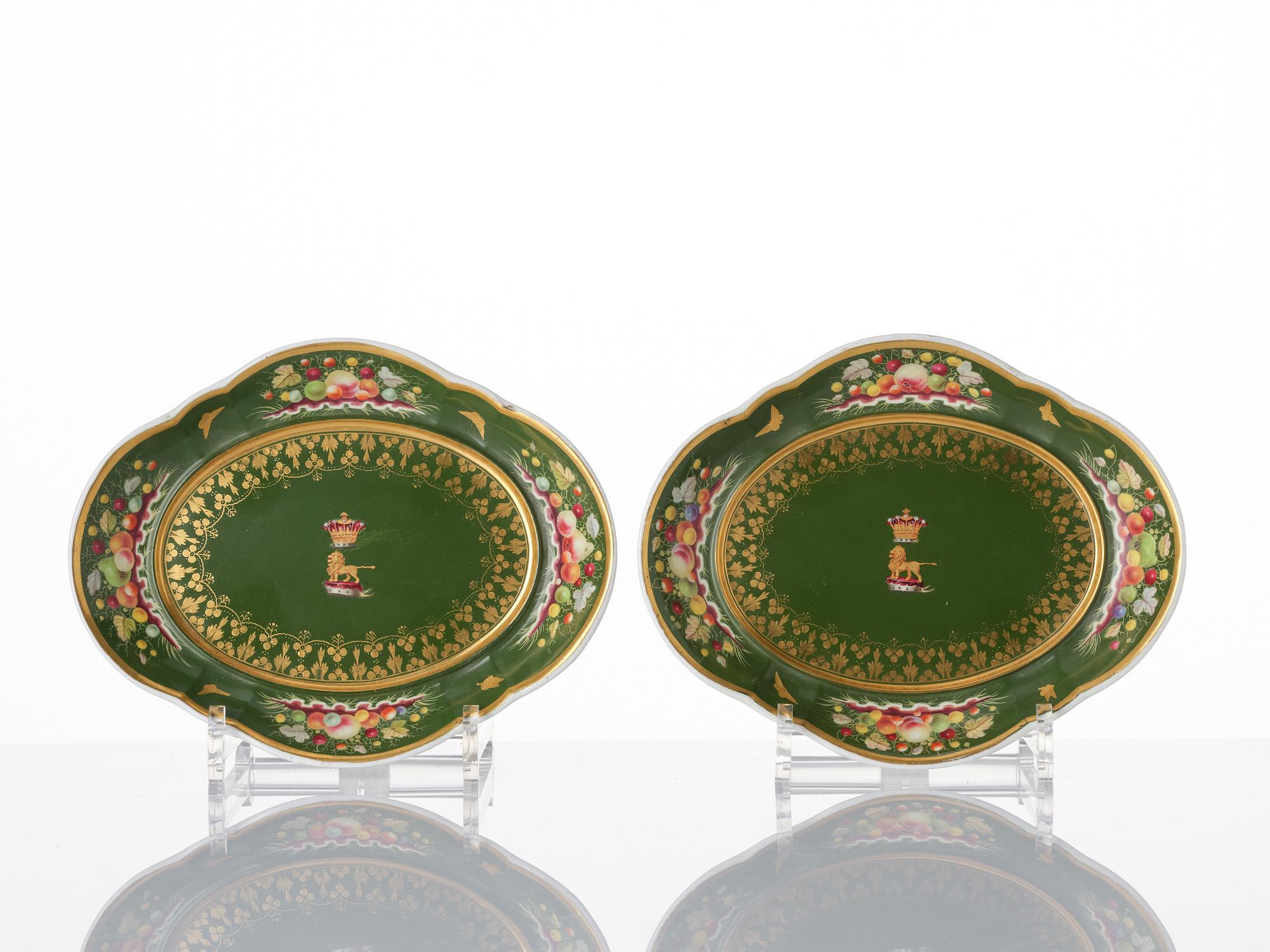 A pair of armorial butter tureens with covers and stands and two fruit dishes, Derby, England, circa 1830.