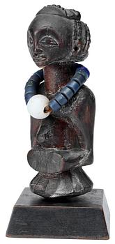 1145. FETISCH. Trä med halsband av glaspärlor. Luba-stammen. Kongo omkring 1900. Höjd 18 cm.