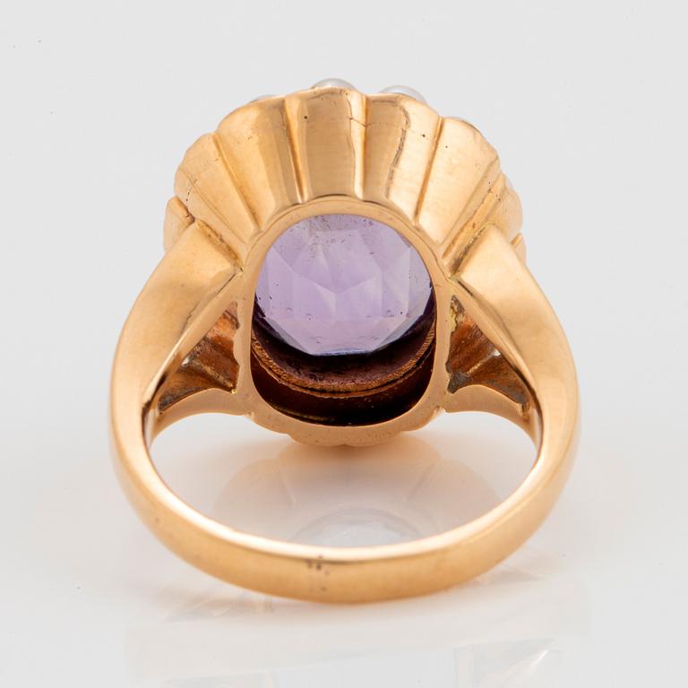 An 18K gold ring set with a faceted amethyst and pearls.