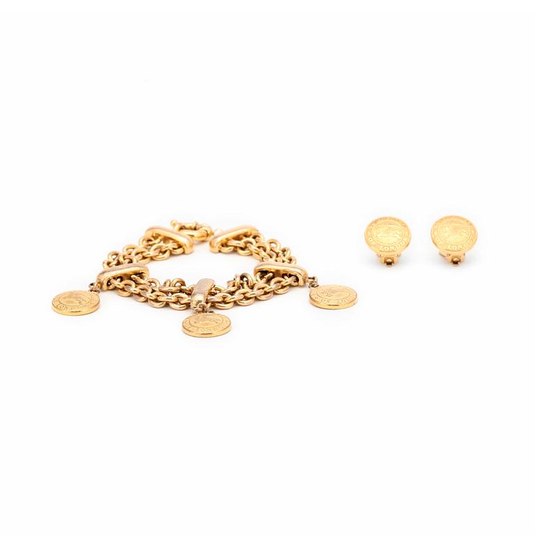 BURBERRY, a gold colored bracelet and clips earrings.