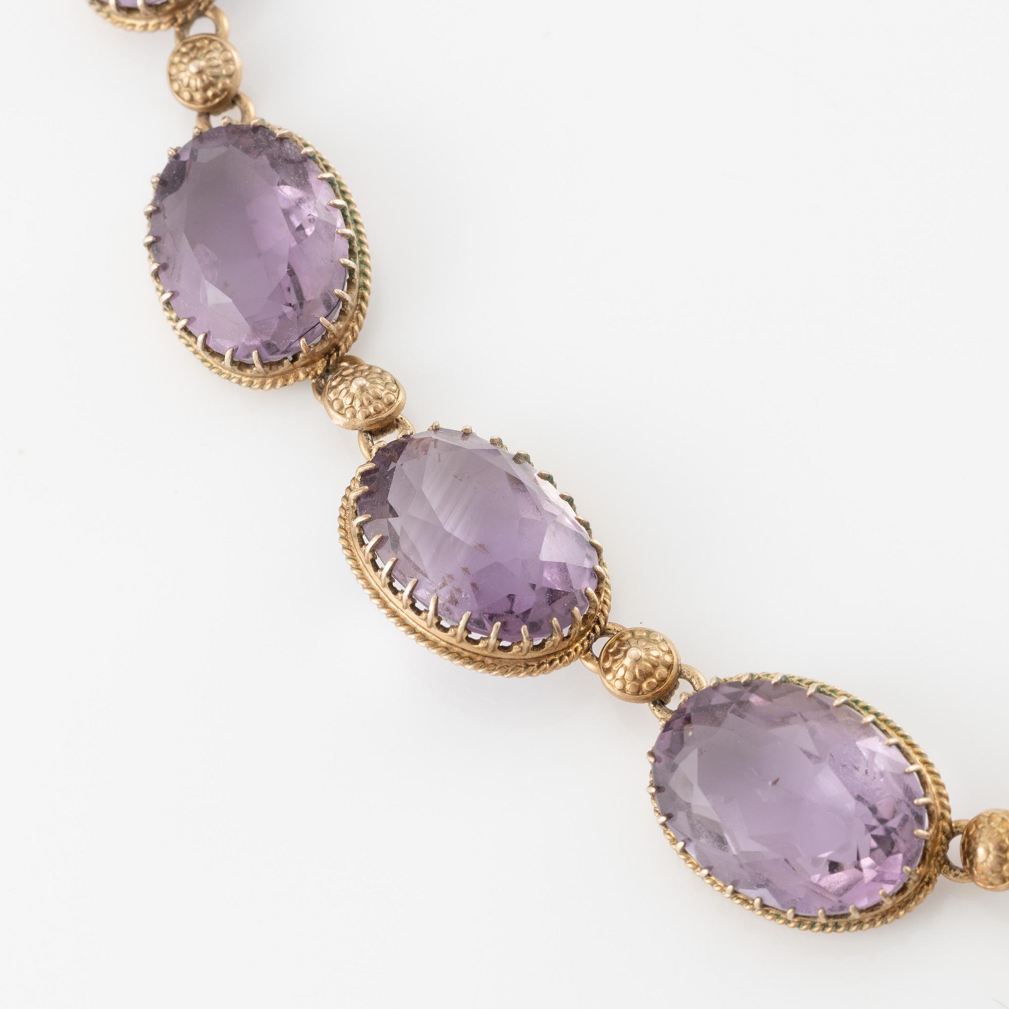 A set with a necklace, a bracelet, a brooch, and a ring.