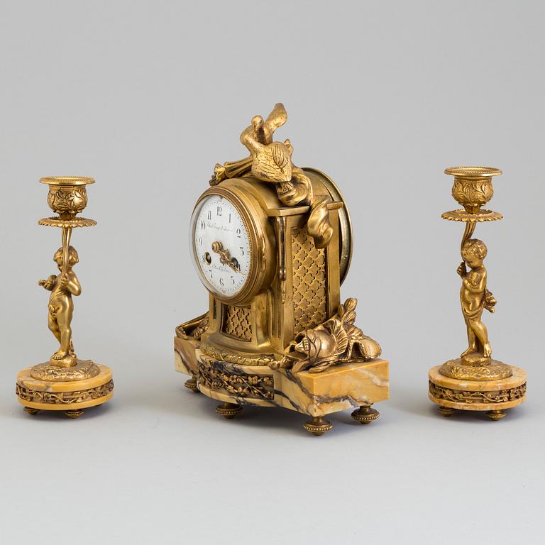 A mantle clock and a pair of candlesticks, early 20th century.