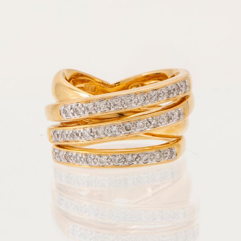 An 18K gold ring set with round brilliant-cut diamonds.