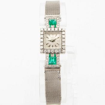 Gübelin bracelet watch in 950 platinum with round brilliant-cut and single-cut diamonds as well as step-cut emeralds.