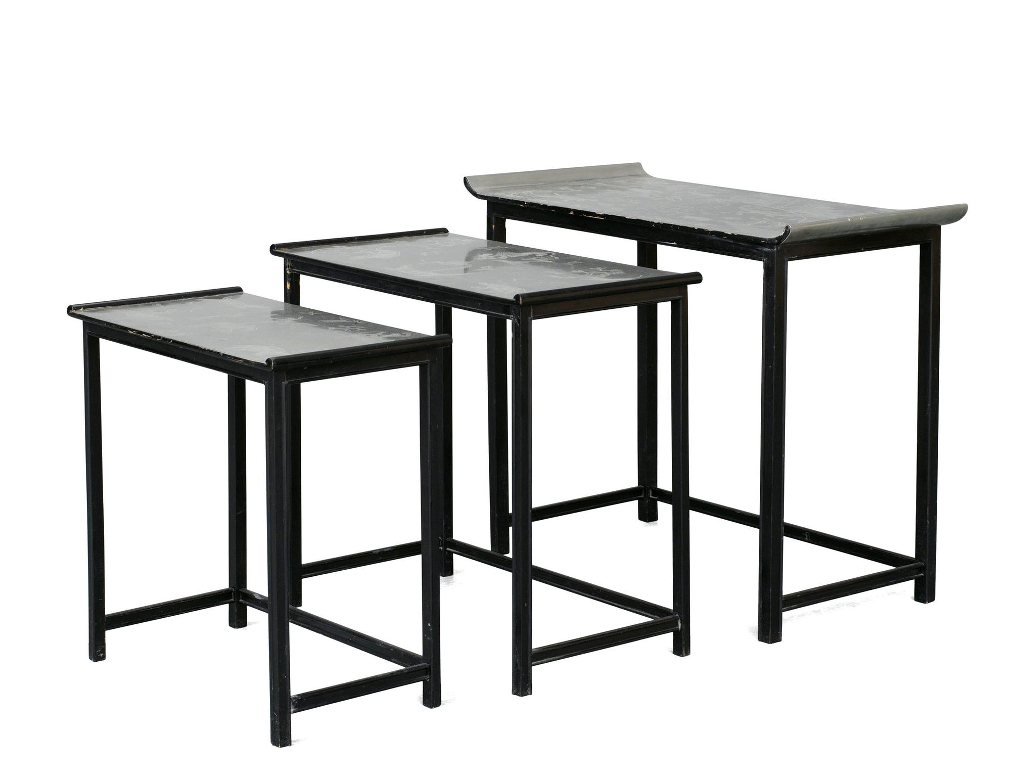 A Nils Fougstedt and Björn Trägårdh set of occasional tables in pewter and black lacquered wood for Svenskt Tenn, circa 1930, the tops with engraved scenes of figures and animals.