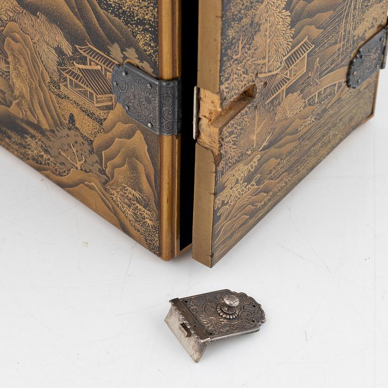 A Japanese lacquer cabinet with tree drawers behind the door, early 20th Century.