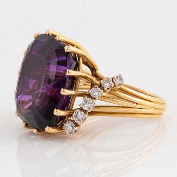 An 18K gold ring set with a faceted amethyst and round brilliant-cut diamonds.