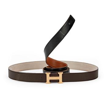 473. HERMÈS, two pairs of reversible belts, black and brown and brown and white leather with gold colored H belt buckle.
