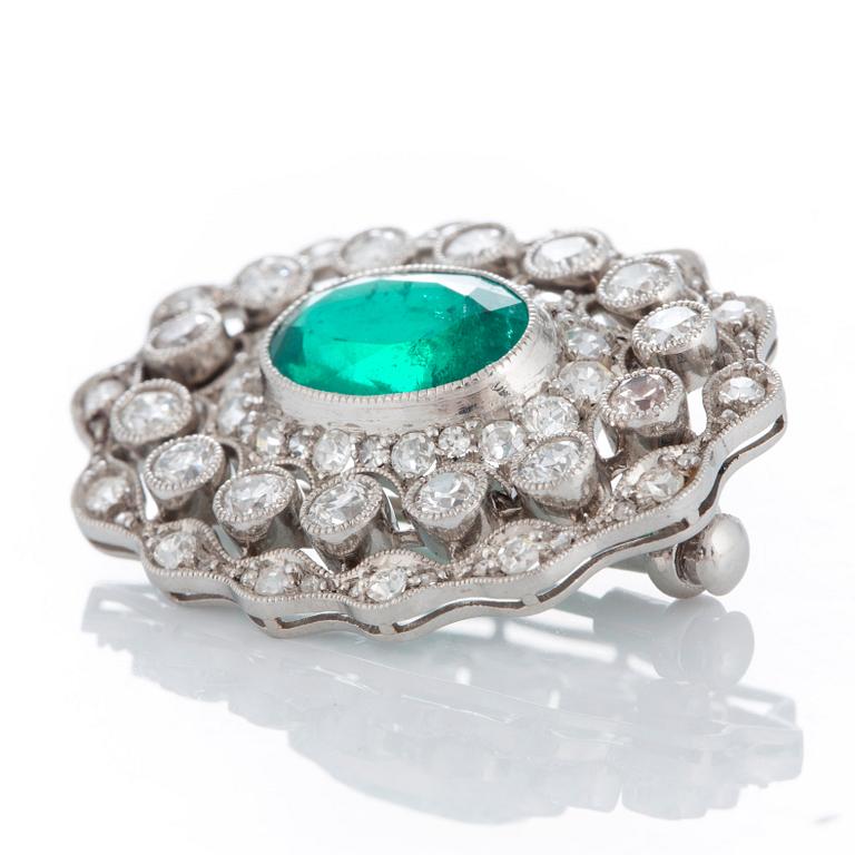 A platinum brooch set with a faceted emerald ca 3 cts and old- and eight-diamonds.