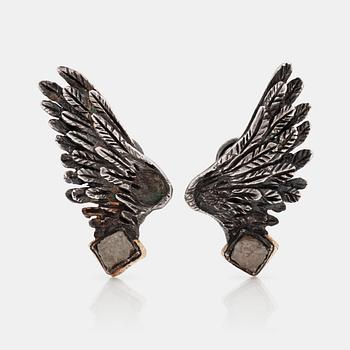 A pait of wing shaped earrings set with un cut diamonds buy Torben Hardenberg.