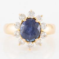 Ring in 18K gold with a faceted sapphire and round brilliant-cut diamonds.