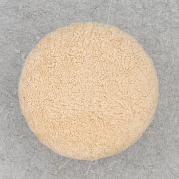 A contemporary stool with birch legs and new sheepskin upholstery.