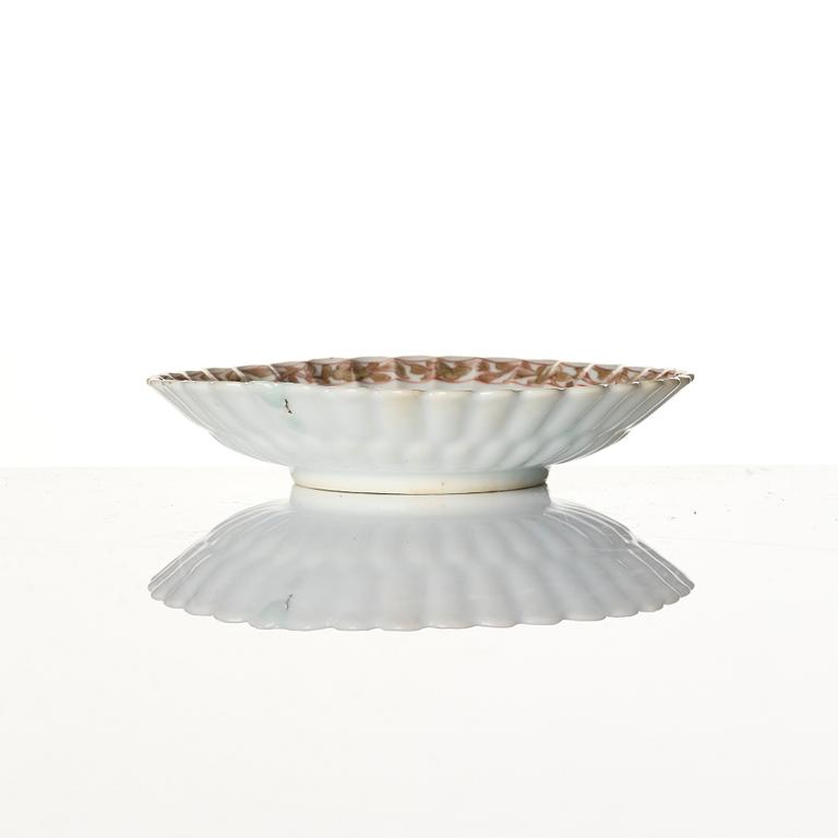 A Chinese iron red porcelain cup with saucer and a small famille verte dish, Qing dynasty, Kangxi (1662-1722).