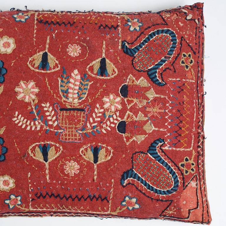 A CARRIAGE CUSHION, "Urnor och blommor", embroidered, ca 48 x 107 cm, Scania, Sweden 1830.
Filled.