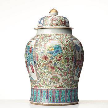 A Canton famille rose jar with cover on a tall wooden stand, Qing dynasty, late 19th Century.