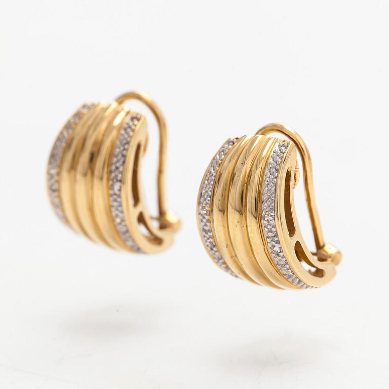 A pair of 18K gold earrings set with small diamonds.