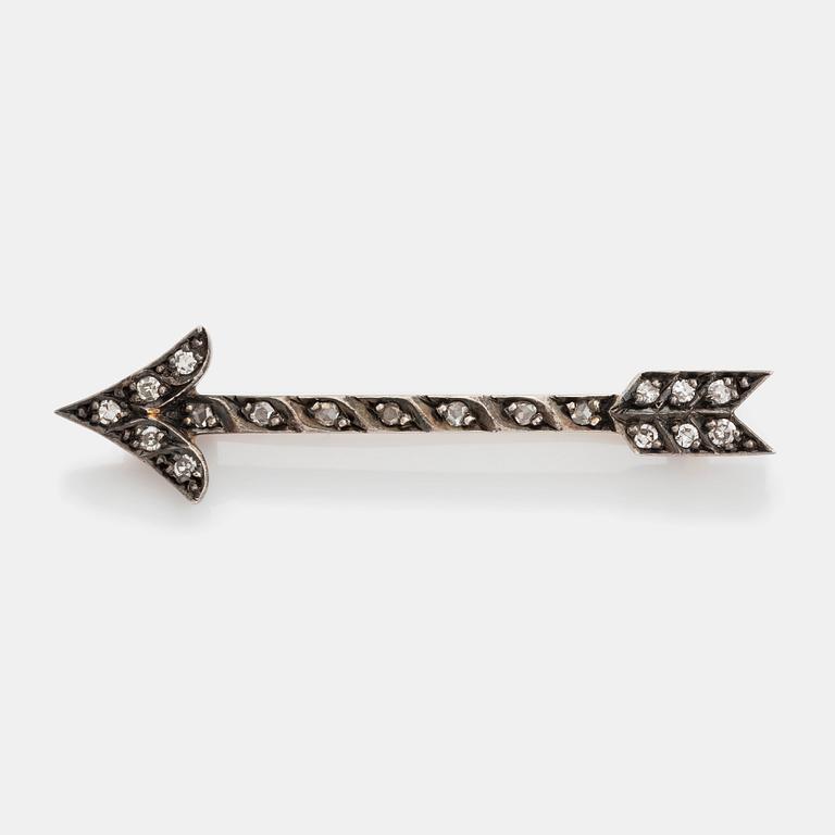 A gold and silver arrow brooch set with eight- and rose-cut diamonds.