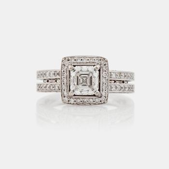 690. A 1.04 ct Assher cut diamond, quality F/VS1, ring. Shan with pavé set brilliant cut diamonds.