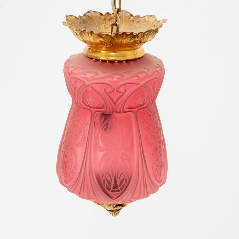 An art noveau glass and brass ceiling lamp from around the year 1900.