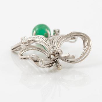 A brooch in 18K white gold with a cabochon-cut emerald.