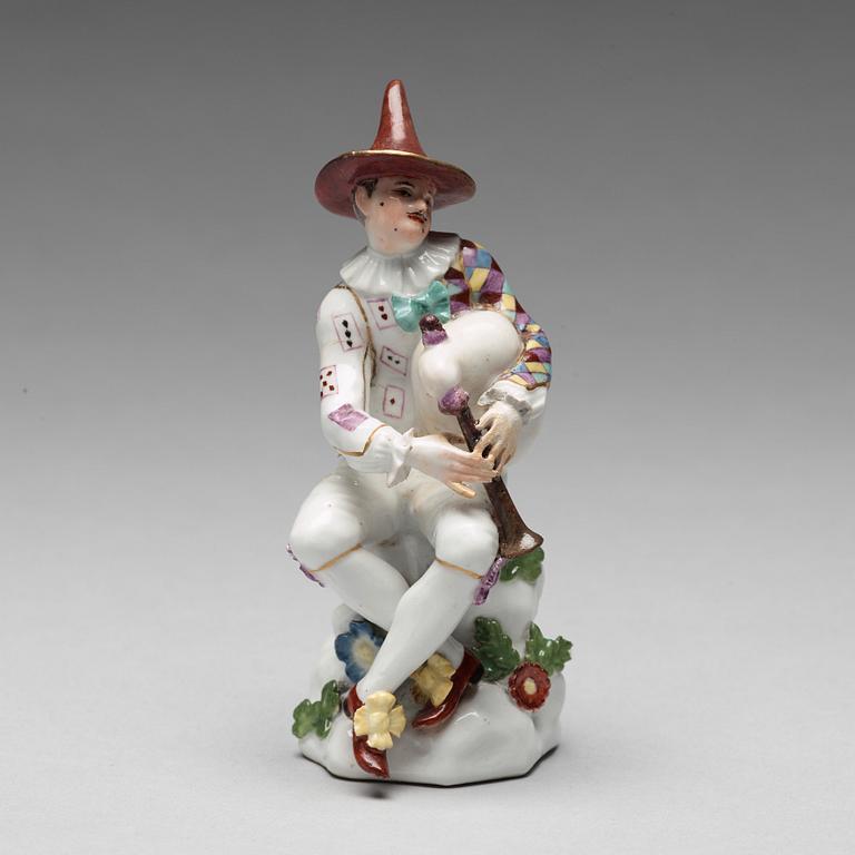 A porcelain figure of harlekin playing the bagpipe, circa 1900.