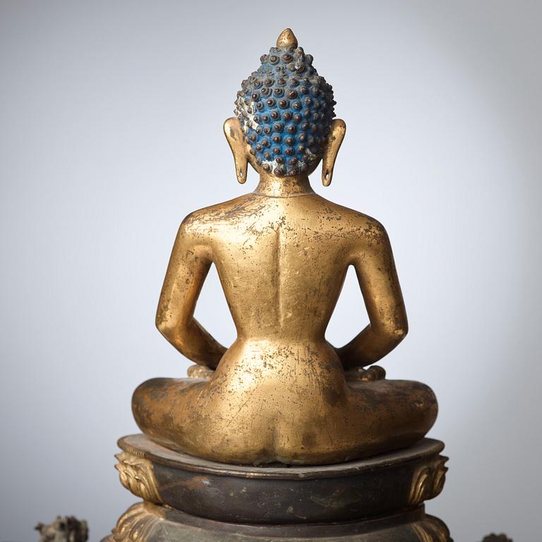 A large Nepalese gilt bronze buddha on a throne with mandorla, 18/19th Century.