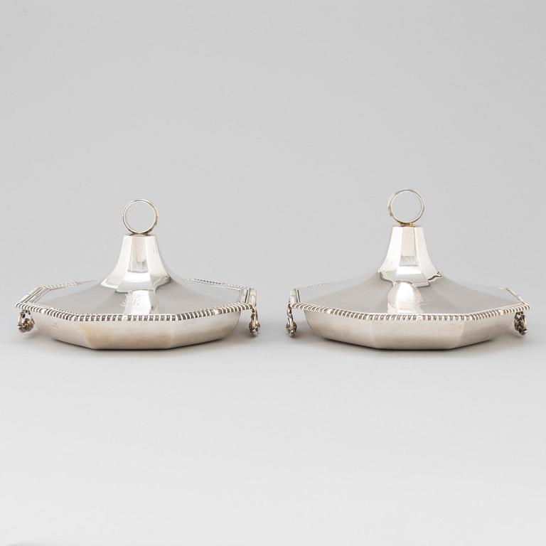 A matched pair of English silver dishes and covers, marked London 1910 and 1912.