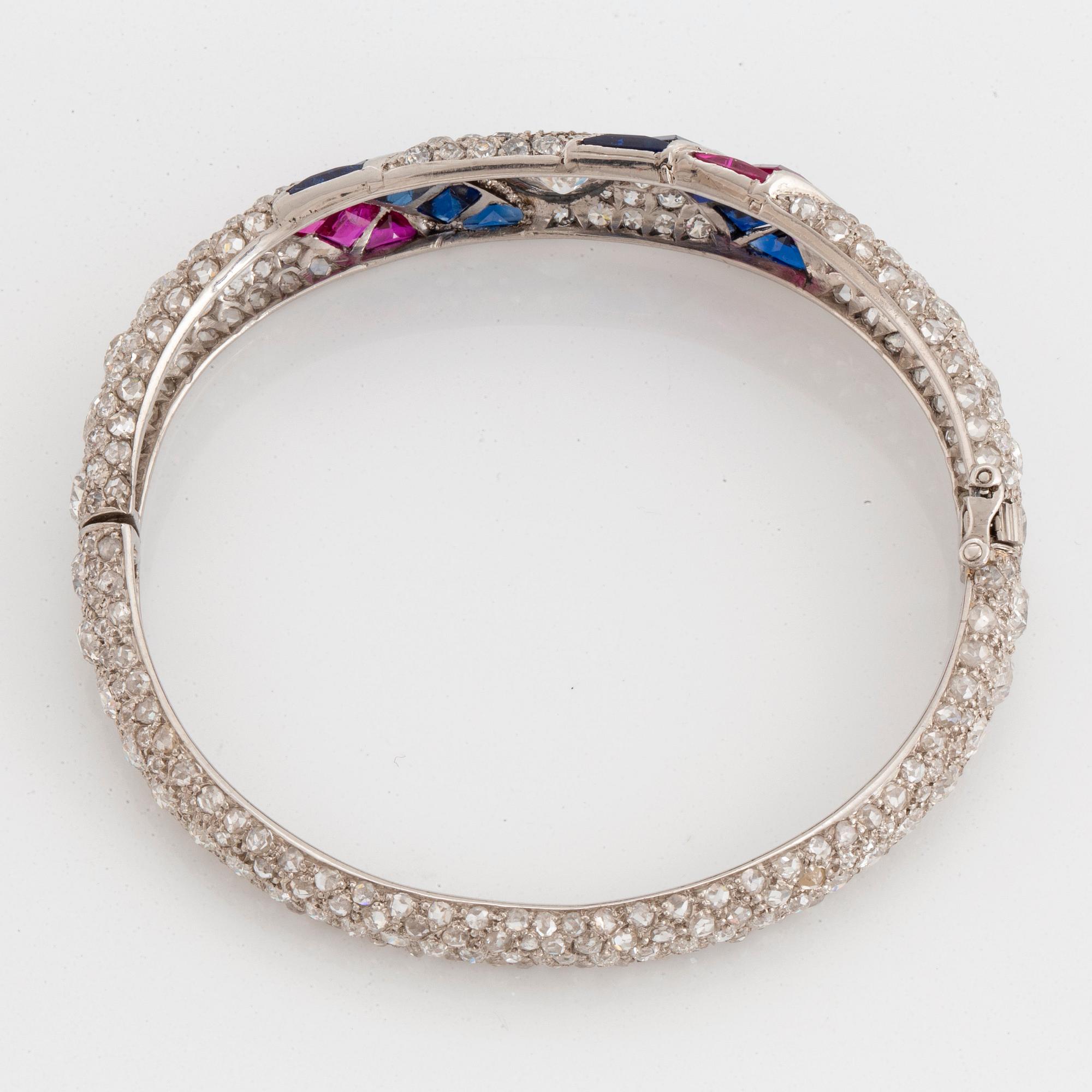 Armring platina med gammal- och rosenslipade diamanter samt fasettslipade safirer och rubiner.