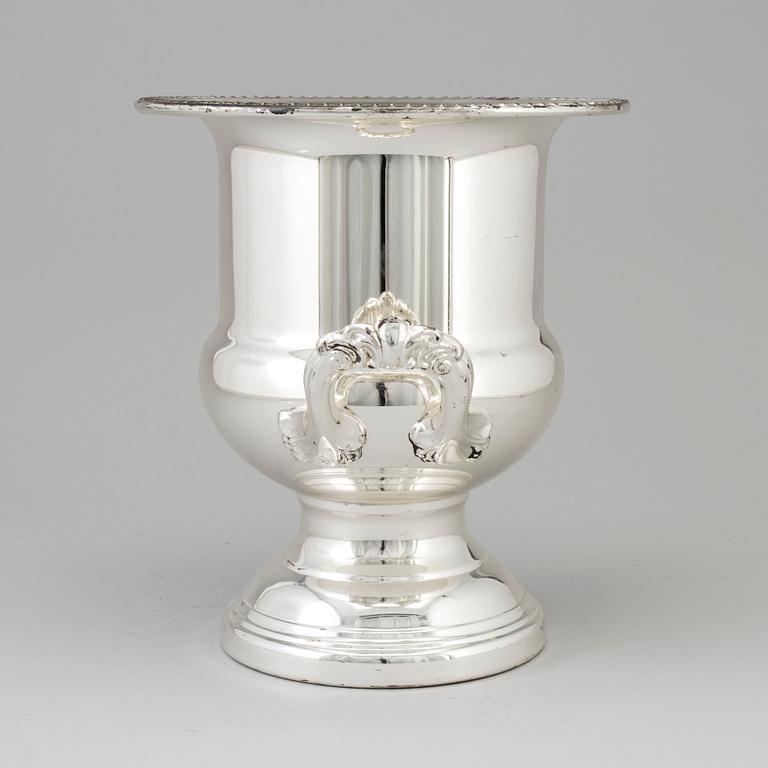 A 20TH CENTURY SILVERVED METAL CHAMPAGNE COOLER.