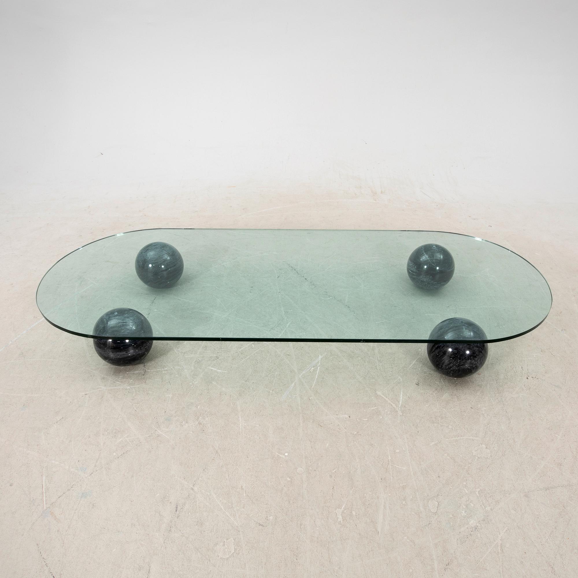 A glass and stone table from the late 20th century.