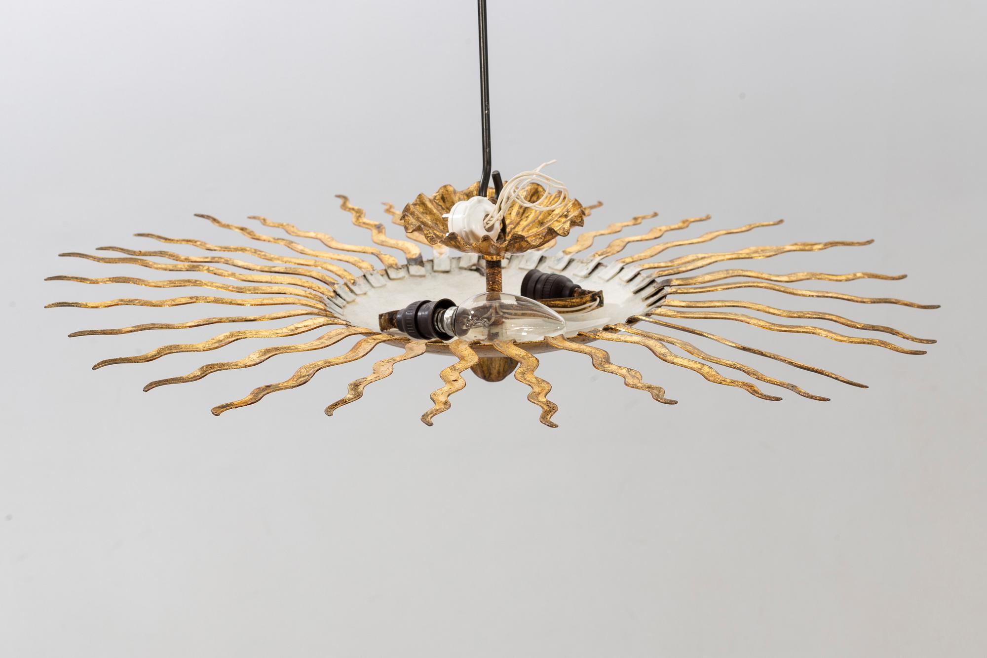 A ceiling lamp in the shape of the sun. Mid 20th century.