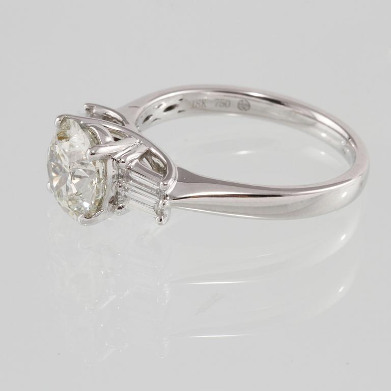 RING, 18K vitguld med briljantslipad diamant 2.00 ct samt 4 baguettslipade diamanter 0.31 ct. Vikt 4,5 gram.