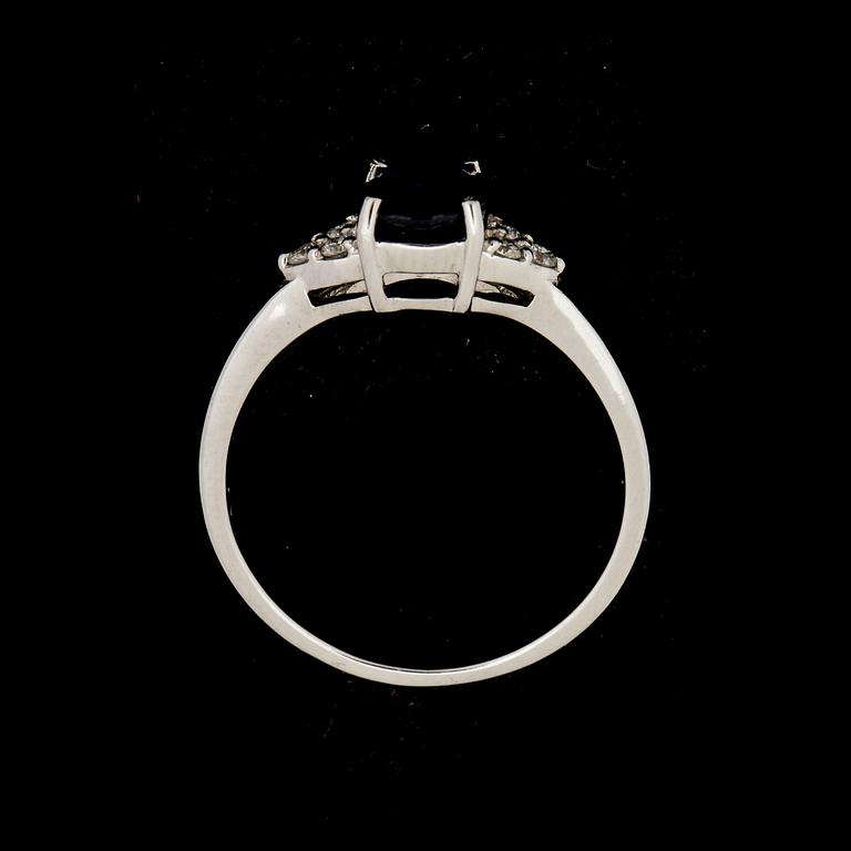 RING, 14 k vitguld med safir ca 1,32 ct, samt 6 mindre briljantslipade diamanter ca 0,06 ct. Vikt ca 2 g.