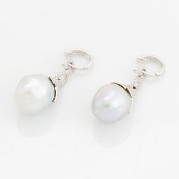 A pair of 18K white gold earrings set with cultured South Sea pearls and round brilliant-cut diamonds.