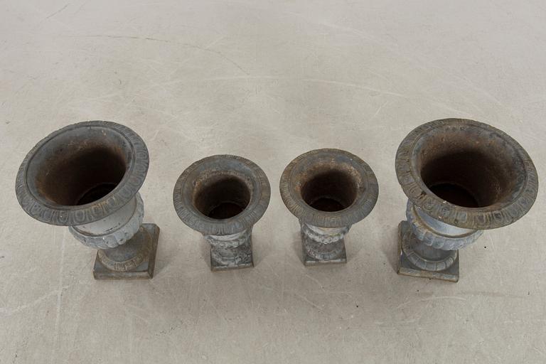 Two pairs of cast iron garden urns.