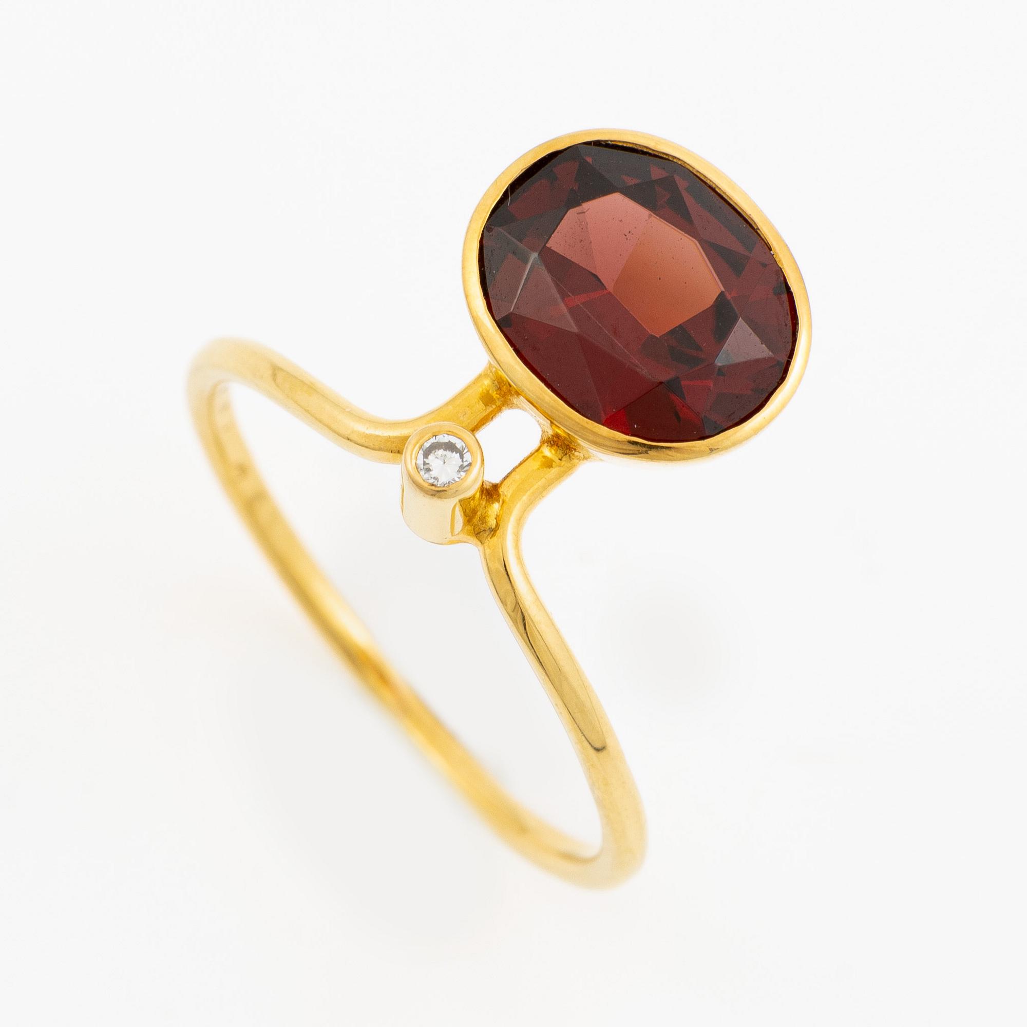 Ring in 18K gold with an oval faceted garnet and a brilliant-cut diamond.