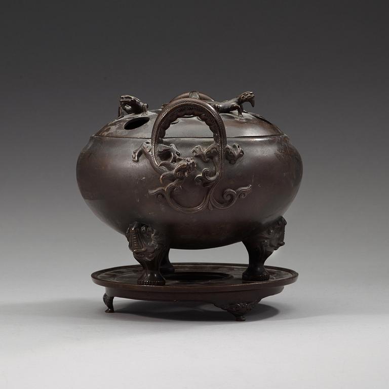 A bronze tripod censer with cover and stand, Qing dynasty, 17/18th Century.