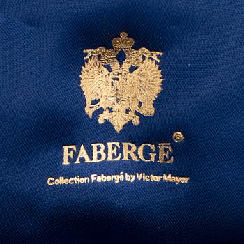 FABERGÉ-ÄGG, 18K guld med blå emalj och runda briljantslipade diamanter, med kedja, med etui.